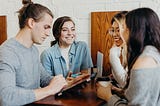 Four people working together at a coffee table