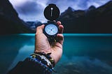 An image of a white person holding a compass for navigation