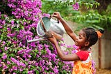 A girl waters plants.