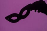 silhouette of a hand holding a mask