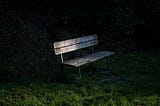 Photo of a dark brown bench with a dark background