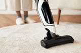 Vacuum cleaning an area rug on a hardwood floor