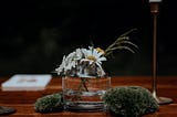 A small wedding centerpiece of foraged flowers and mosses.