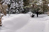 A man steering a snowblower.