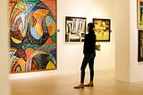 Photo of a girl staring at a colorful in a gallery