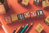 Wooden blocks spelling out the word “school”
