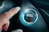 A finger hovers above a button in a car labeled “Autopilot Start/Stop.”