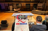 Chimerica Program Held in front of Gymnasium Stage