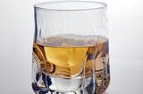 A half-filled square-shaped glass of whisky