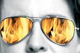 Kara Swisher wearing glasses with flames reflected from her Burn Book cover