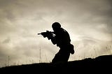 A man in a black jacket holding a rifle.