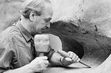 Black and white picture of a sculpturer Henry Moore at work.