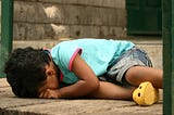A young child crying, sprawled out on the floor.