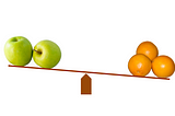 Scale with apples on one side and oranges on the other