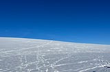 A snowy hill and a clear blue sky