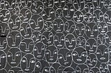 Repeating pattern of drawn faces.