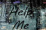 the words ‘help me’ written on a steamed up window
