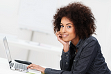 Woman with natural hair typing on laptop