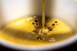 Color photo of coffee dripping into a white mug or coffee cup.