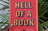 A picture of the “hell of a book” book cover with palm leaves in the background.