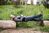 Tim Ferriss lying between two logs