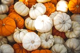a pile of orange and white mini pumpkins