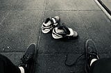 A pair of weightlifting shoes sitting on the floor.