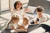 Mother throwing her hands in air, overwhelmed by the children with her.