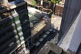 A view from the apartment down to the city street, with a construction site next door