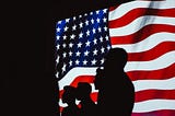 Silhouettes of people in front of the American flag