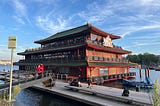 this is a photo of a chinese restaurant that looks like a large boat floating on the water. It has a sign saying Sea Palace on the side