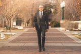 Salvador Aceves walks outdoors on the Regis University Northwest Denver campus.
