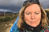 woman in hiking gear with dark skies behind