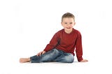 Jamie posing in red top and jeans on a white background