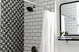 black & white tiled shower, white shower curtain open