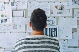 Man looking at wall of paper | Photo by Startup Stock Photos from Pexels