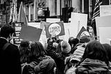 Image of protesters holding signs during a rally.