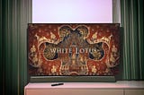 Television screen displaying the title screen of the TV series The White Lotus.