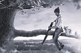 Picture of a man looking blissfully unaware while sawing off the branch of a tree as he’s sitting on the end that will fall to the ground.