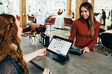 Two woman standing across a counter from one another