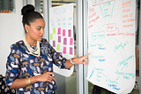 Woman pointing at diagram in office.