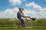 A Man Sitting On His Bicycle Holding His Partner