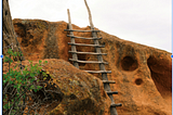 A ladder against a rugged hill.