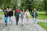 Six young teens walking in the park