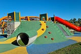 A children’s playground with slide, tunnel and climbing wall