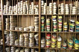 Shelves in a shoe shop, subdivided into sections, all containing espadrilles in a range of different colours