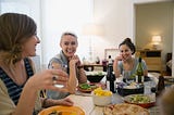 Friends laughing and enjoying dinner party