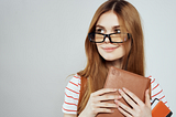 girl with glasses holding a notebook