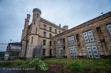 A gothic castle-like limestone structure with turrets and a gloomy sky.