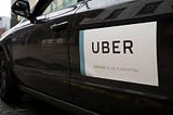 An Uber car with the company logo attached.